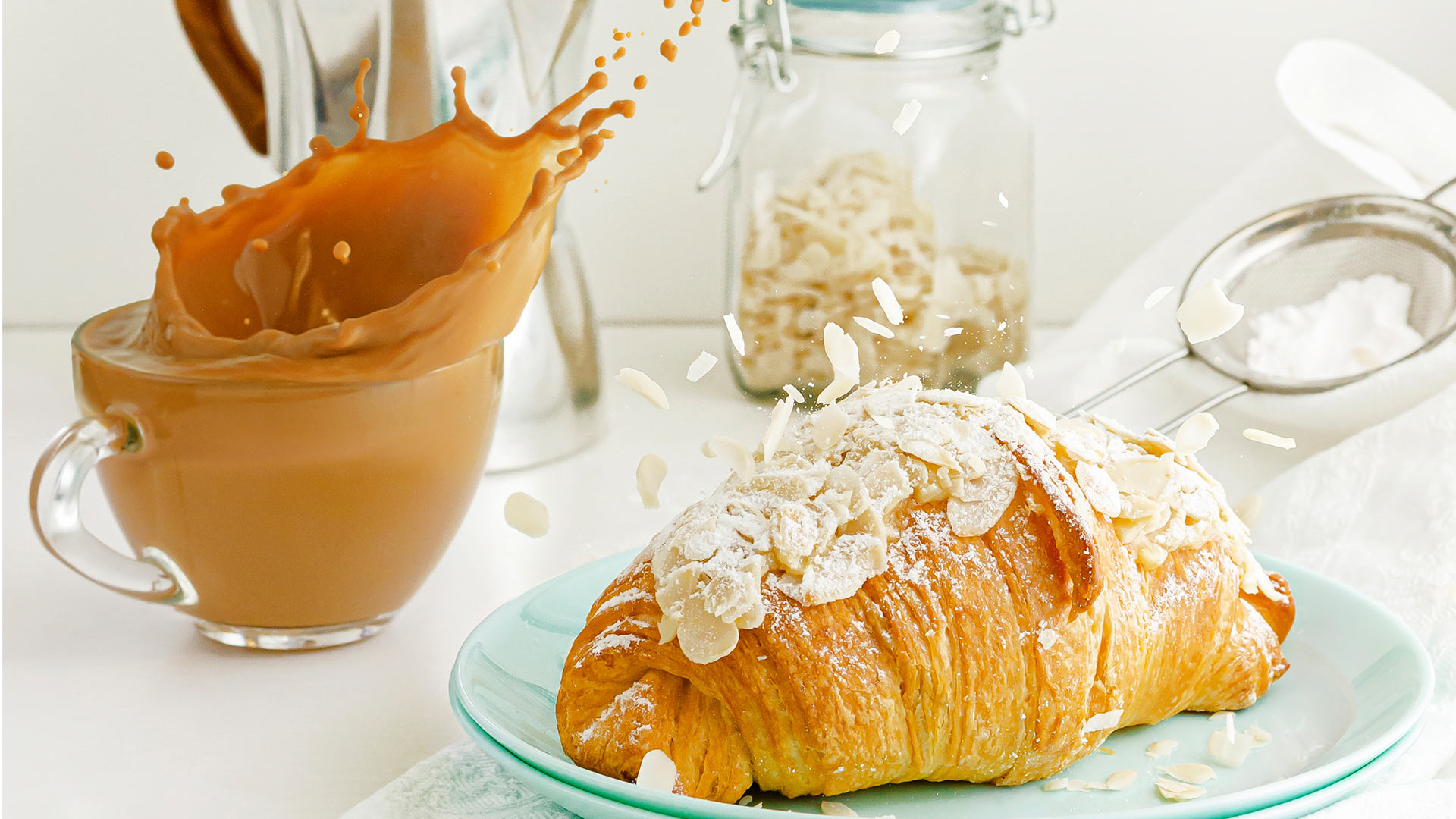 almond croissant with a splashing cup of coffee