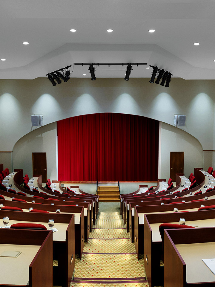 small auditorium with red curtain covering the stage