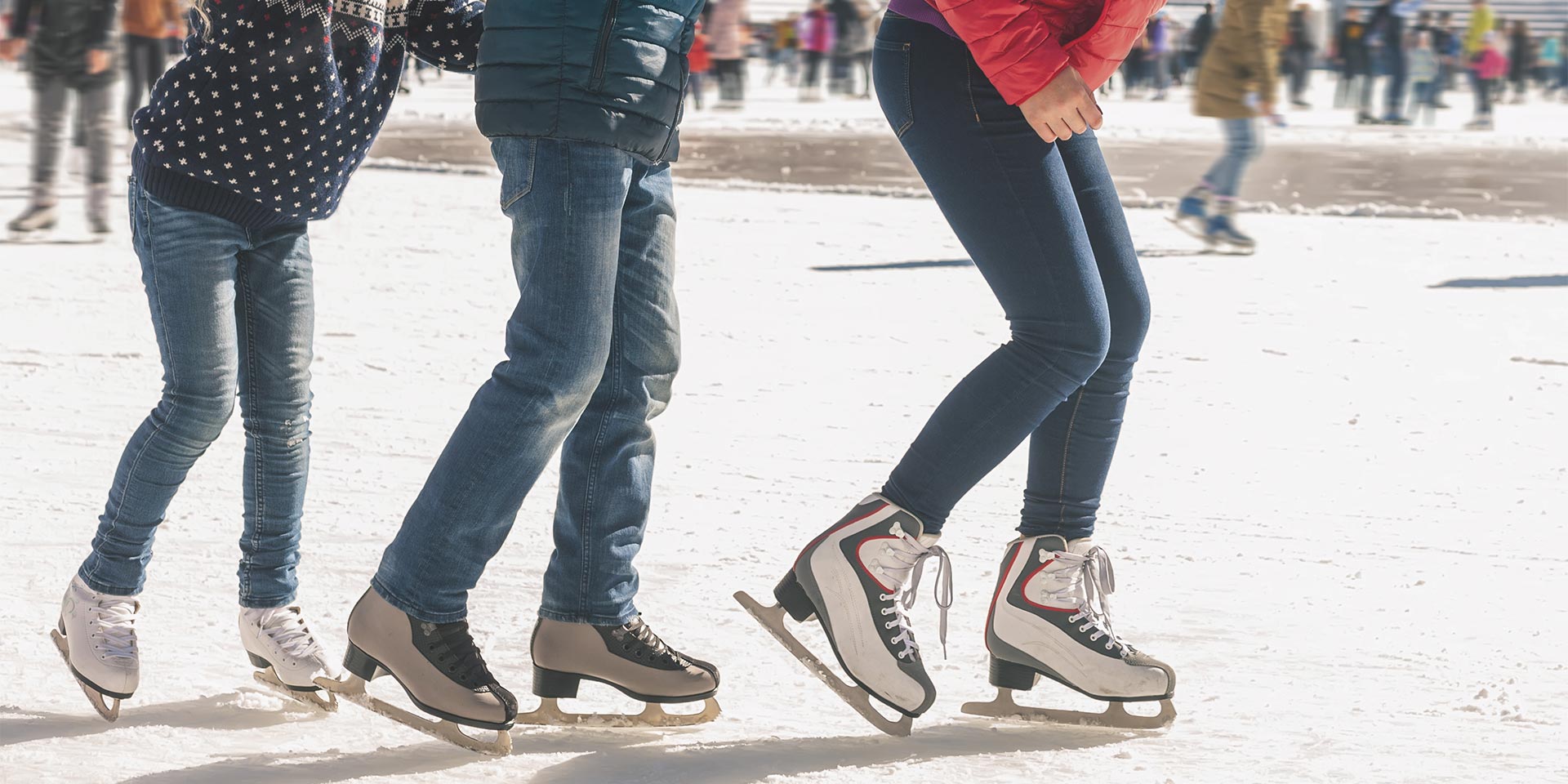 three people ice skating