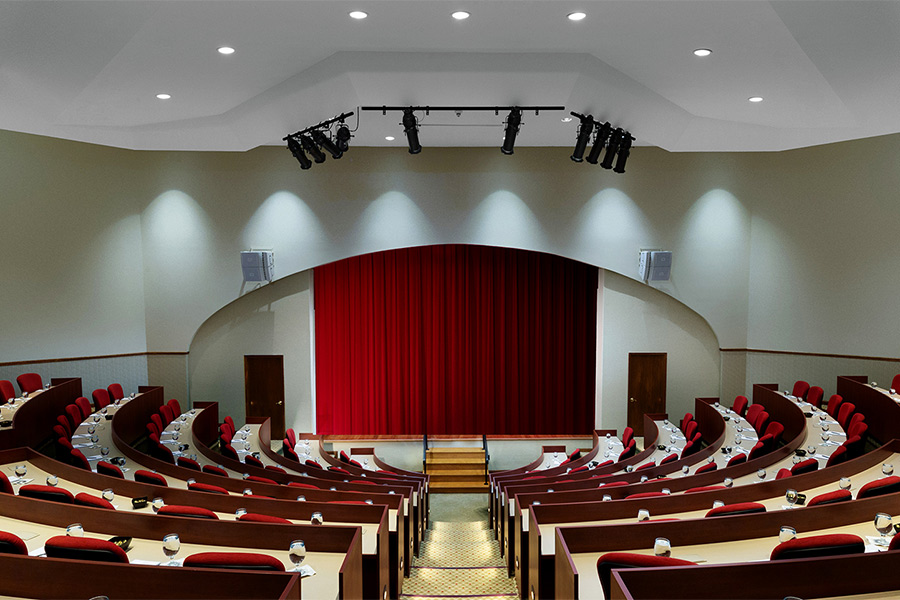 large semicircle auditorium with red curtains on stage