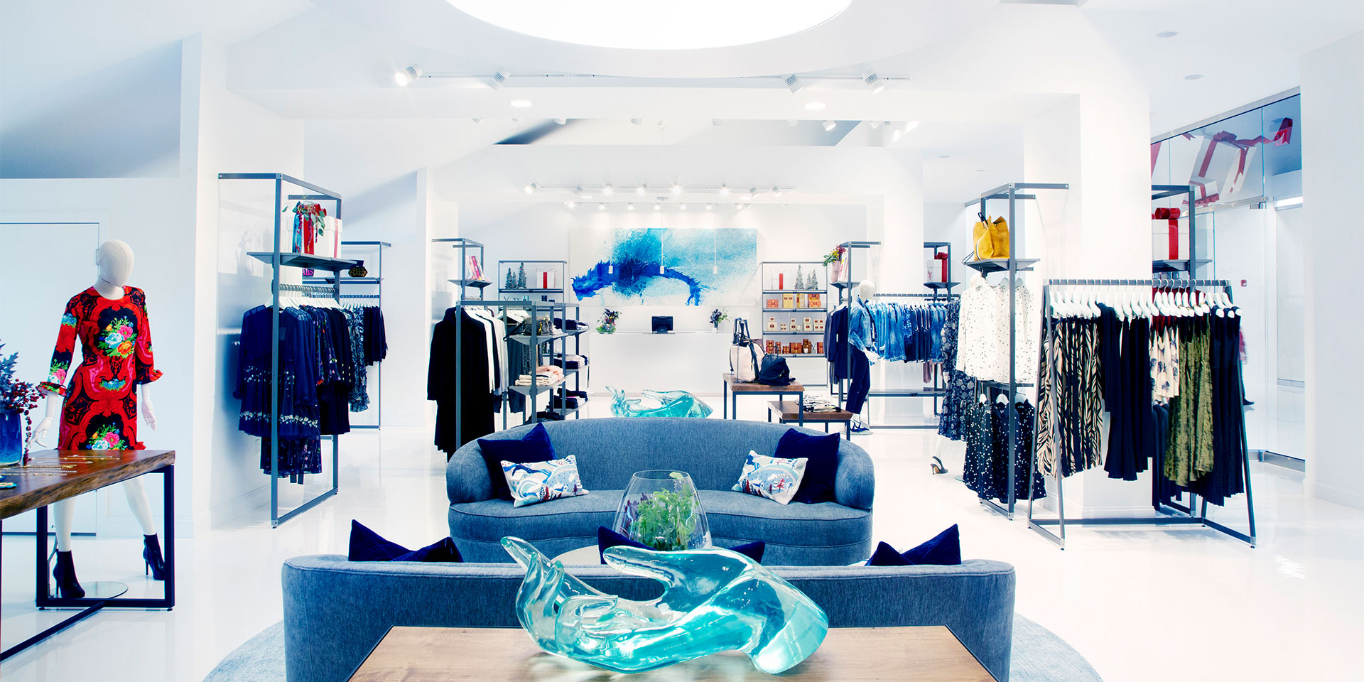 interior of a white fancy clothing store with blue couches