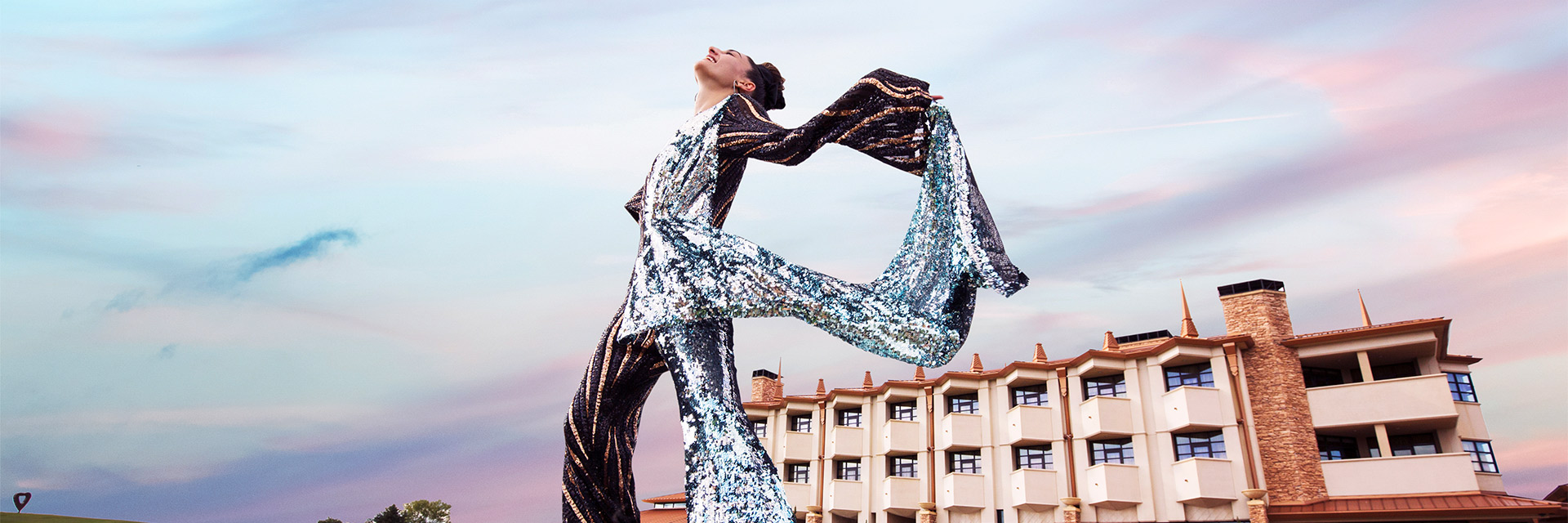 A woman in a sparkly putfit poses infront of Nemacolin