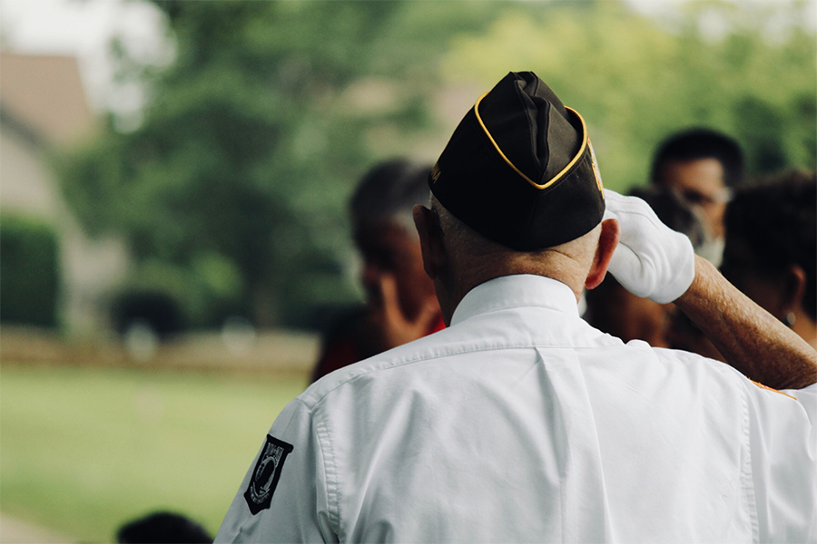 the back of the head of a man in a veteran's cap