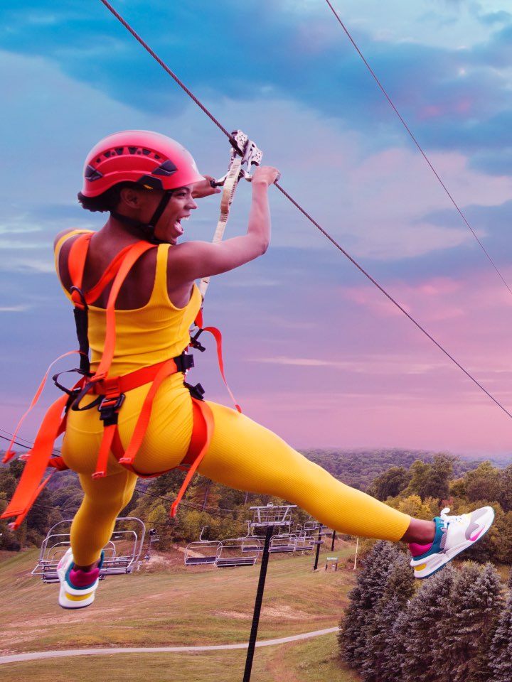 Two people going down a zip line