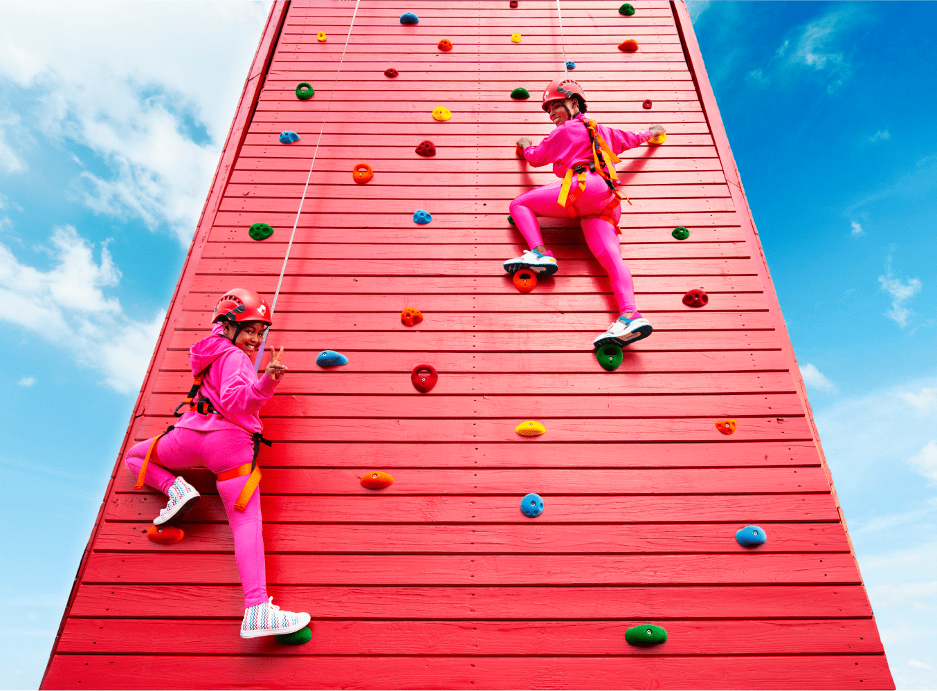 People climbing on a red climbing wall