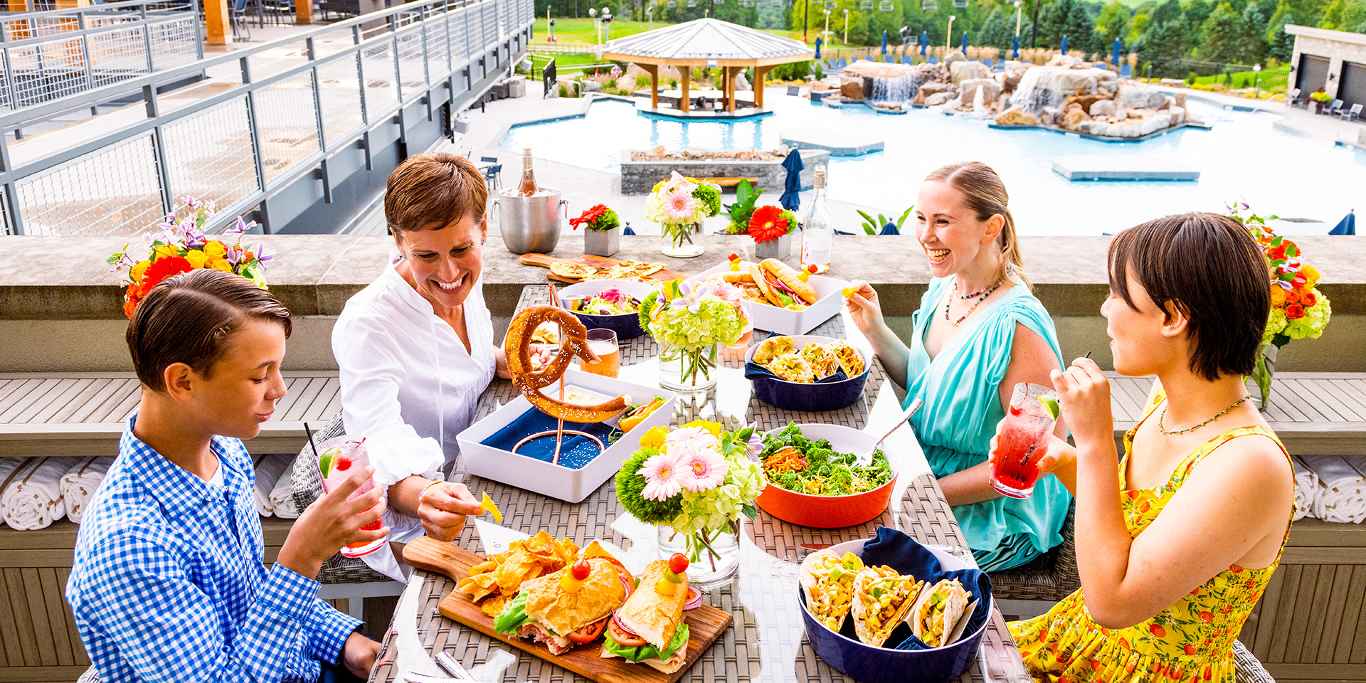 family enjoying dinner on pool deck