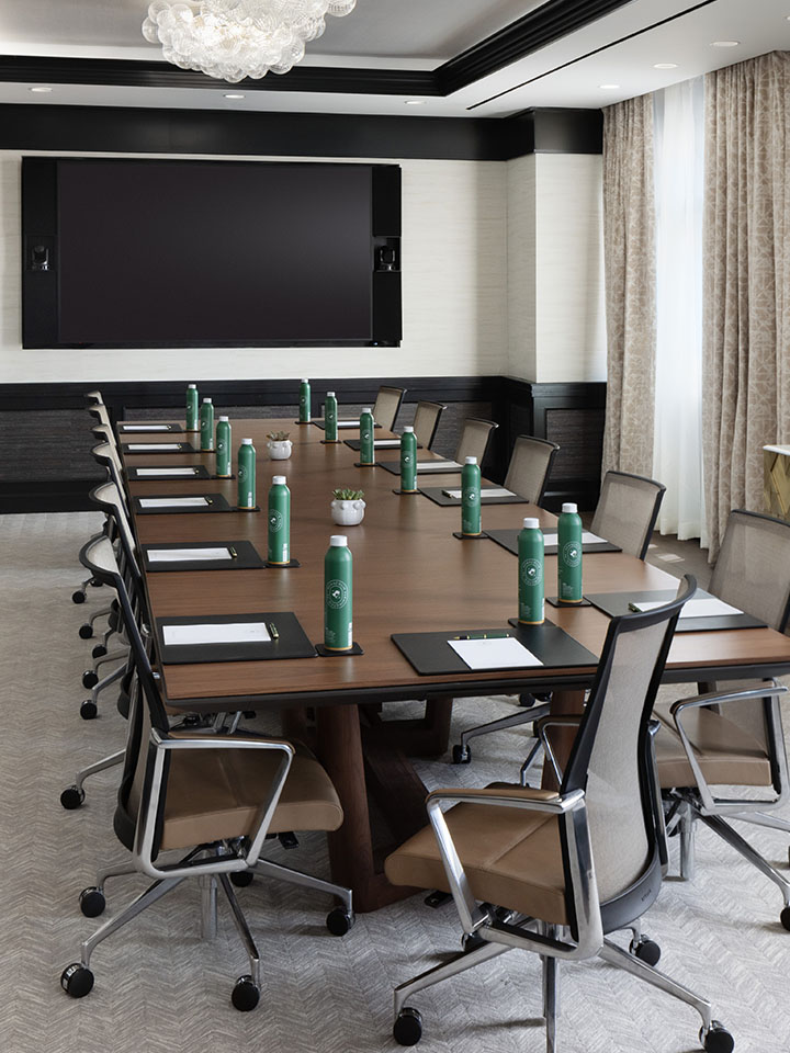 Rectangle wooden table in boardroom setup for a meeting.