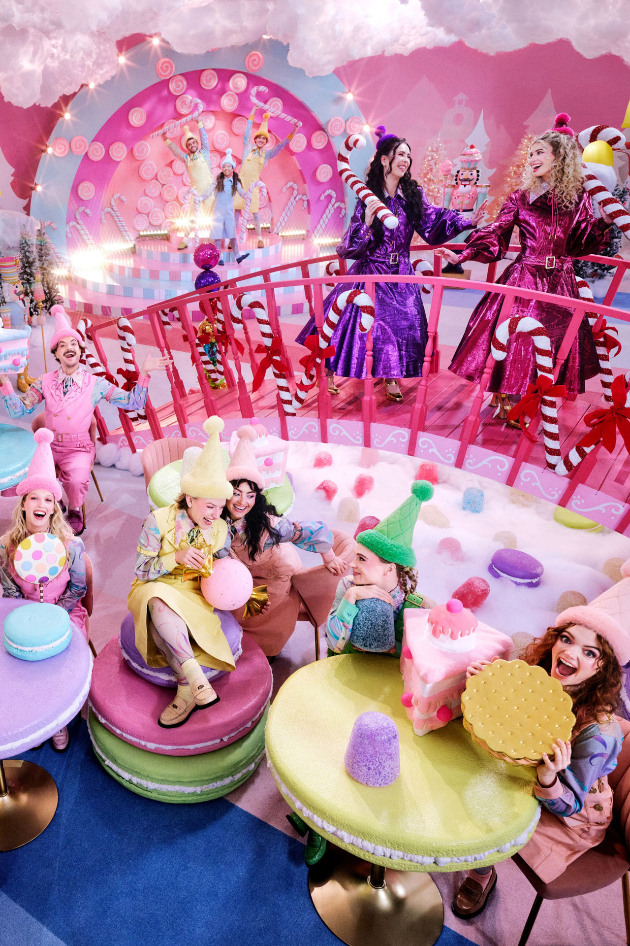 Click here to open the gallery overlay for the image: playful image of people in costume in a candy land like setting