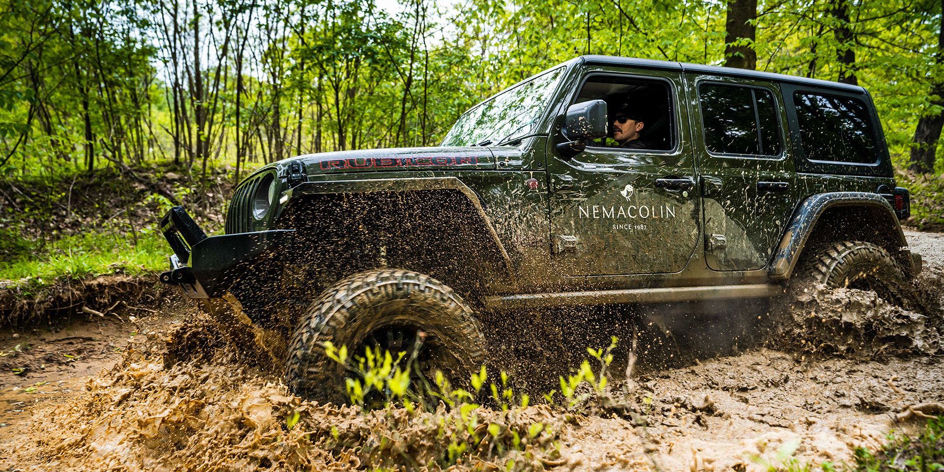 Jeep Wrangler driving through mud
